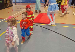 Dzieci przechodzą po czerwonym dywanie demonstrując swoje stroje