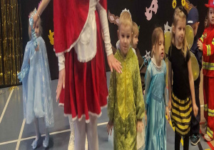 Pani przebrana za czerwonego kapturka prowadzi dzieci w pociągu