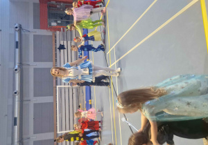 Pani przebrana za Alicje z Krainy Czarów prowadzi dzieci w pociągu