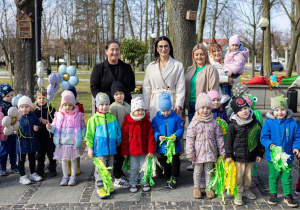 Dzieci świętują nadejście wiosny, trzymają w ręce balony, są ubrane w kolorowe stroje