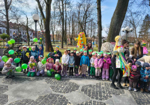 Dzieci świętują nadejście wiosny, trzymają w ręce balony, są ubrane w kolorowe stroje