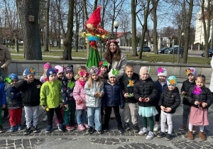 Dzieci świętują nadejście wiosny, trzymają w ręce balony, są ubrane w kolorowe stroje