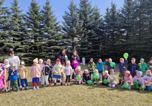 Dzieci stoją w dużym kole, pośrodku ognisko na którym palą się marzanny