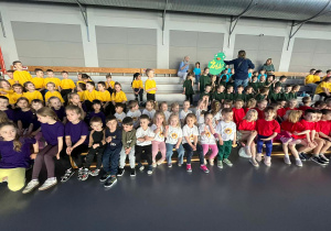 Na trybunach siedzą uczestnicy olimpiady przyglądając się zmaganiom swoich kolegów.