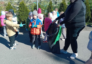 Dzieci na spacerze zbierają śmieci