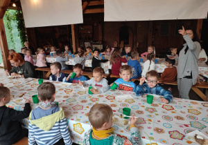 dzieci siedzą przy stole i jedzą