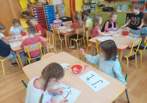 Dzieci wyklejają literkę T kolorową pianką
