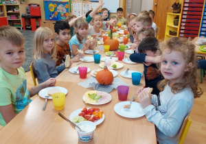 Dzieci jedzą przy stole przygotowane kanapki