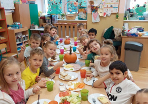 Dzieci jedzą przy stole przygotowane kanapki