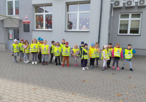 Dzieci stoją przed budynkiem Przedszkola