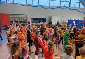 Duża grupa dzieci tańczy do muzyki przebrana w różne stroje jesienne