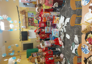 Dzieci zdzierają kolorowy papier z prezentów