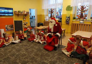 Dzieci siedzą w kręgu z Mikołajem
