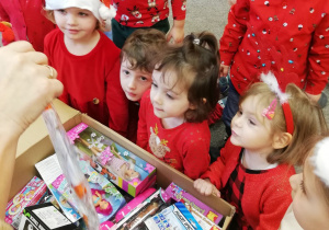 Dzieci otwierają prezent od Św. Mikołaja.