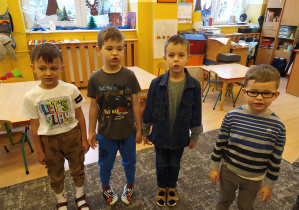 czterech chłopców stoi na dywanie