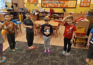 dzieci stoją obunóż na krążkach sensorycznych