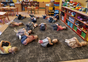 dzieci leżą na dywanie na plecach nogi podkulone
