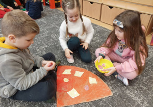 Dzieci komponują swoją pizzę z papieru