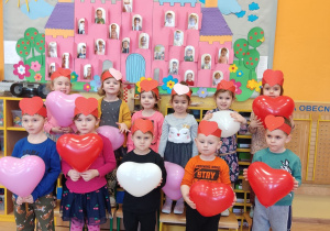 Dzieci trzymają balony i pozują do wspólnego zdjęcia.