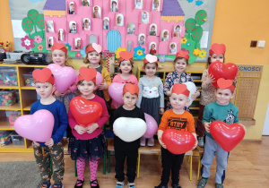 Dzieci trzymają balony i pozują do wspólnego zdjęcia.