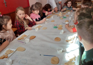 Dzieci dekorują zajączki z ciasta kruchego