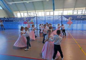 Grupa dzieci tańczy w parach chłopcy z dziewczynkami
