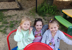 Trzy dziewczynki kręcą się na karuzeli.