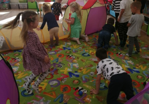 Dzieci bawią się na dywanie.