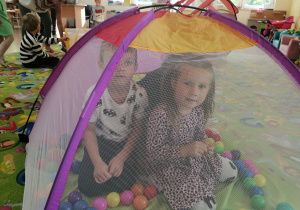 Dzieci bawią się w namiocie z piłkami.