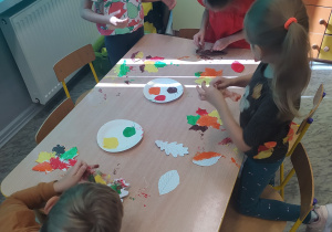 Dzieci malują farbami jesienne liście