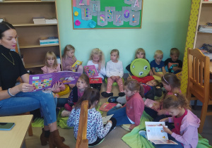 Dzieci słuchają czytanej książki.
