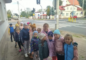 Dzieci stoją na chodniku przy skrzyżowaniu.