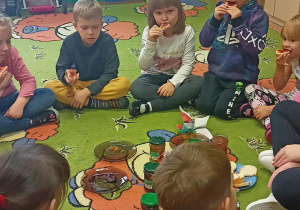 Dzieci jedzą kanapki z dżemem.