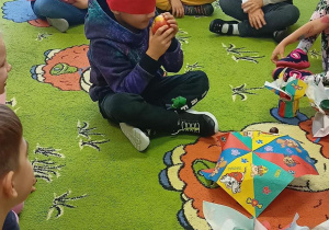Chłopiec rozpoznaje owoc przy pomocy zmysłu dotyku i węchu.