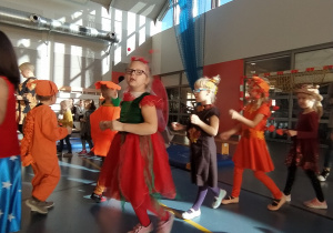 dzieci tańczą w jesiennych strojach