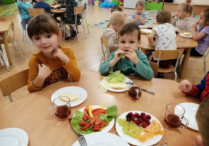 Dzieci pozują do zdjęcia podczas śniadania.