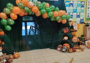 Hol przedszkola udekorowany balonami i zieloną tkaniną oraz napisem Dzień Dyni