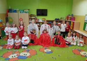 Grupa dzieci ubranych na biało-czerwono pozuje do zdjęcia z kołami hula-hop, z których utworzyły flagę Polski.
