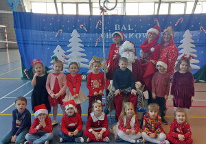 Dzieci pozują do zdjęcia z Świętym Mikołajem i elfami
