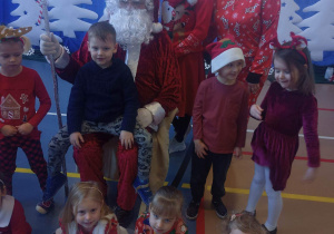 Dzieci pozują do zdjęcia z Świętym Mikołajem i elfami