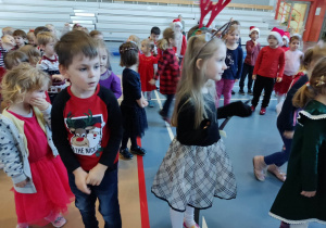 Grupa dzieci tańczy w rytm muzyki.