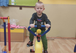 Chłopiec ćwiczy na rowerku.